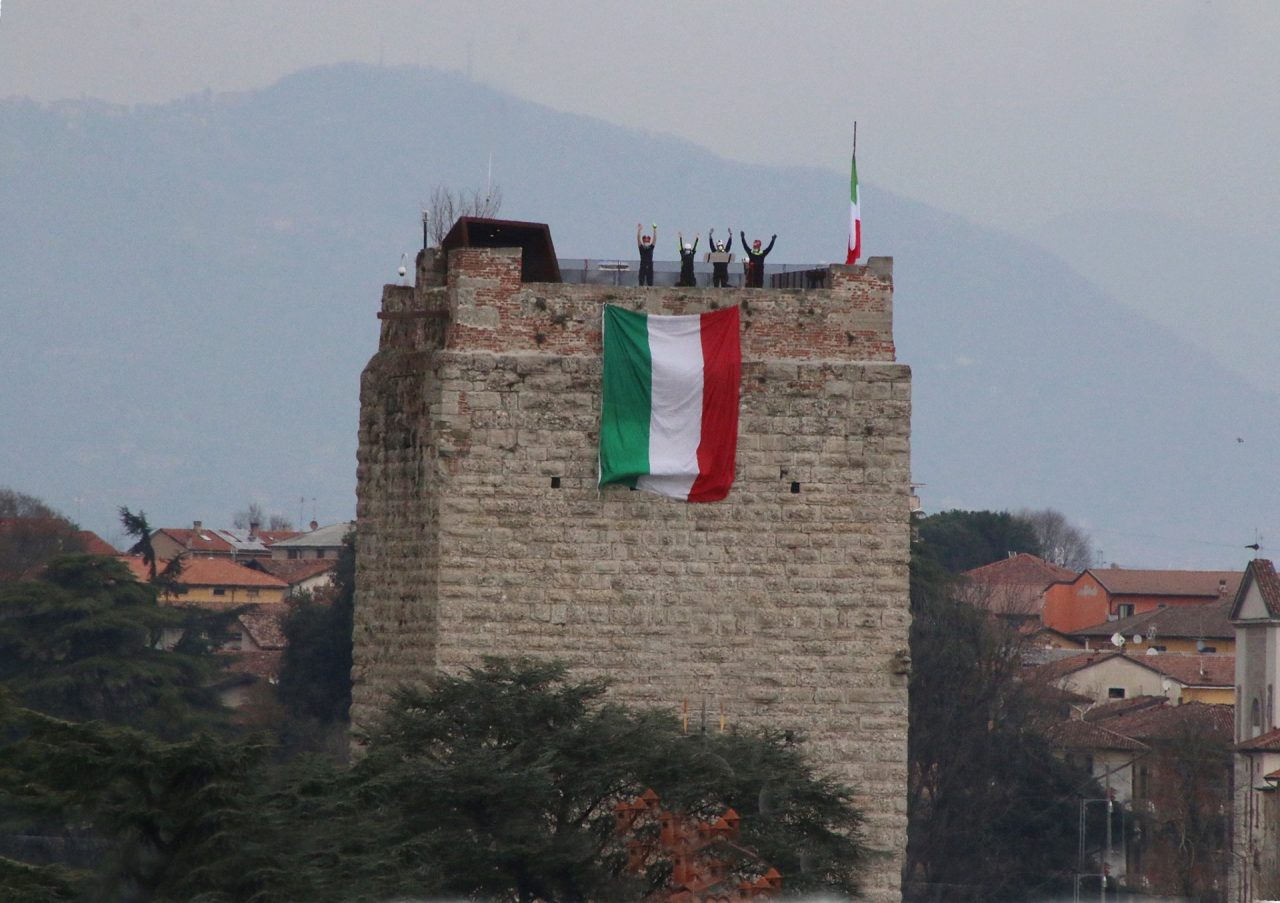 Una grande bandiera tricolore sventola sulla Torre del Castello Visconteo contro il Coronavirus