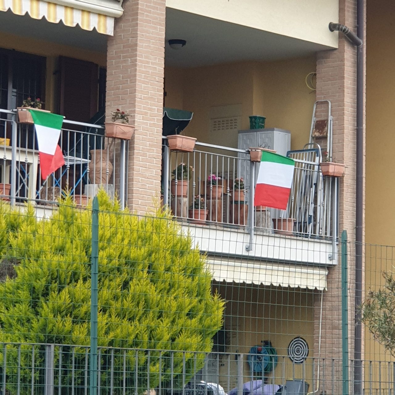 Tantissime bandiere tricolori alle finestre e nelle vetrine di Cassina