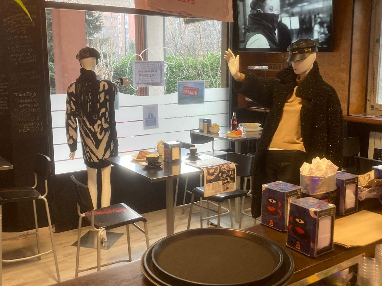 Clienti nel bar seduti ai tavoli, ma sono… manichini