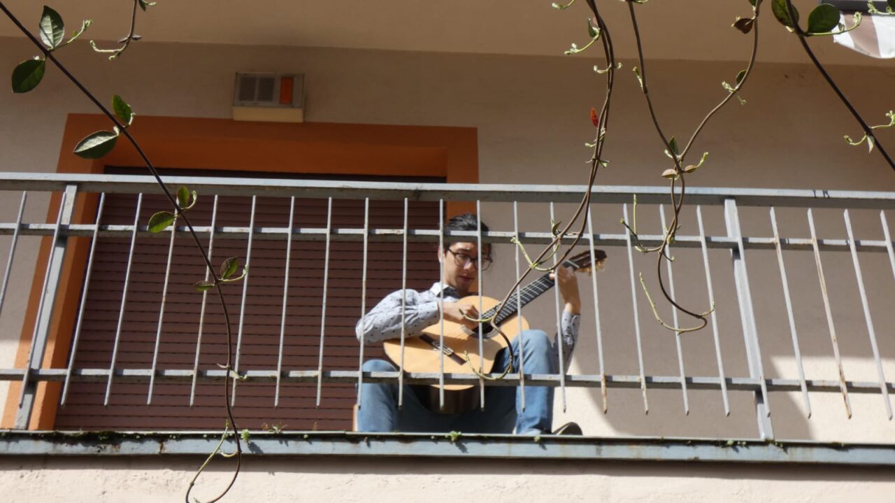 Suona sul balcone come nel primo lockdown: chitarrista torna in Italia per coltivare la sua passione