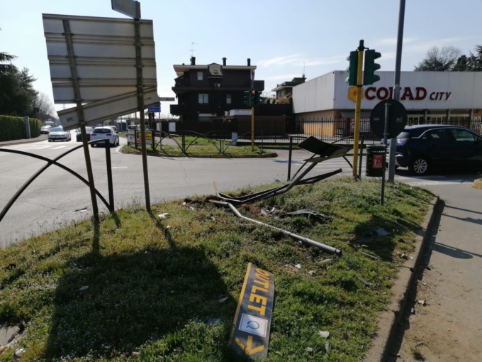Auto tira dritto al semaforo ed esce fuori strada: abbattuti pali e cartelloni