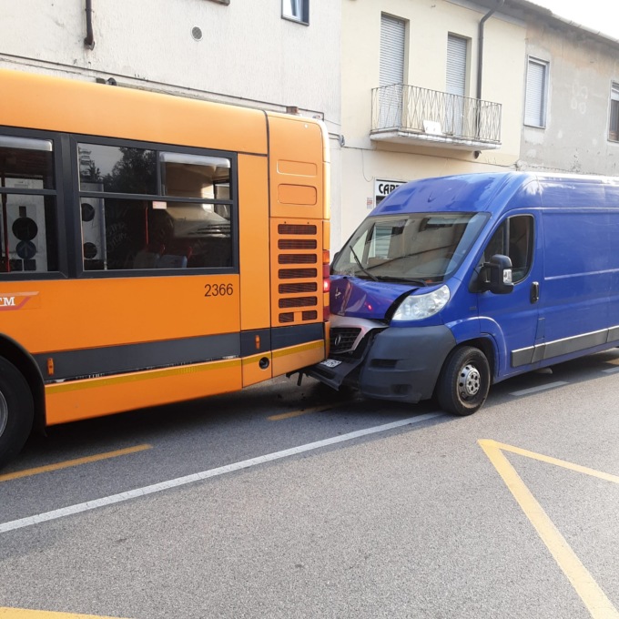 Furgone tampona autobus di linea con passeggeri a bordo