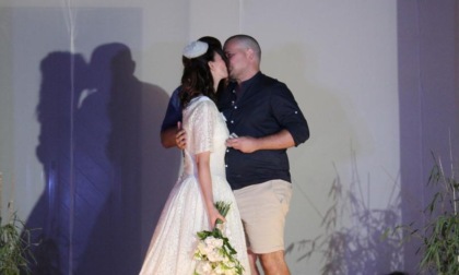 La sua fidanzata sfila con gli abiti da sposa storici, lui sale sul palco e le chiede la mano davanti a tutti