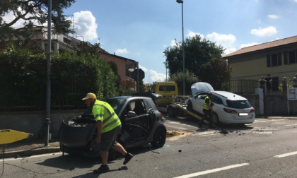 Violento scontro a un incrocio, auto si ribalta sul marciapiede