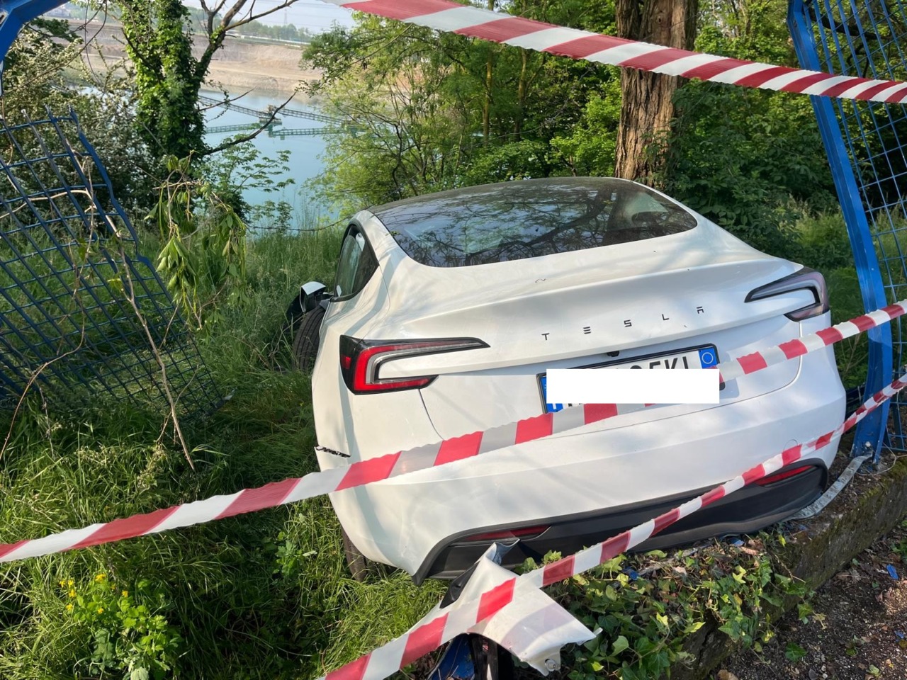 Tesla nuova di zecca sfonda la recinzione e resta sospesa sul laghetto